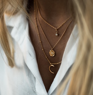 woman wearing gold necklace and white shirt