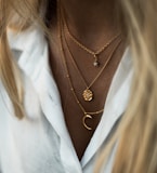 woman wearing gold necklace and white shirt