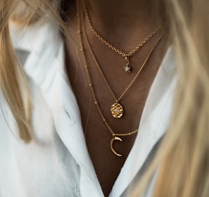 woman wearing gold necklace and white shirt