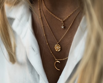 woman wearing gold necklace and white shirt
