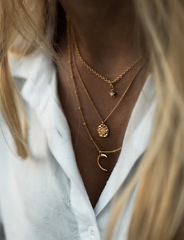 woman wearing gold necklace and white shirt