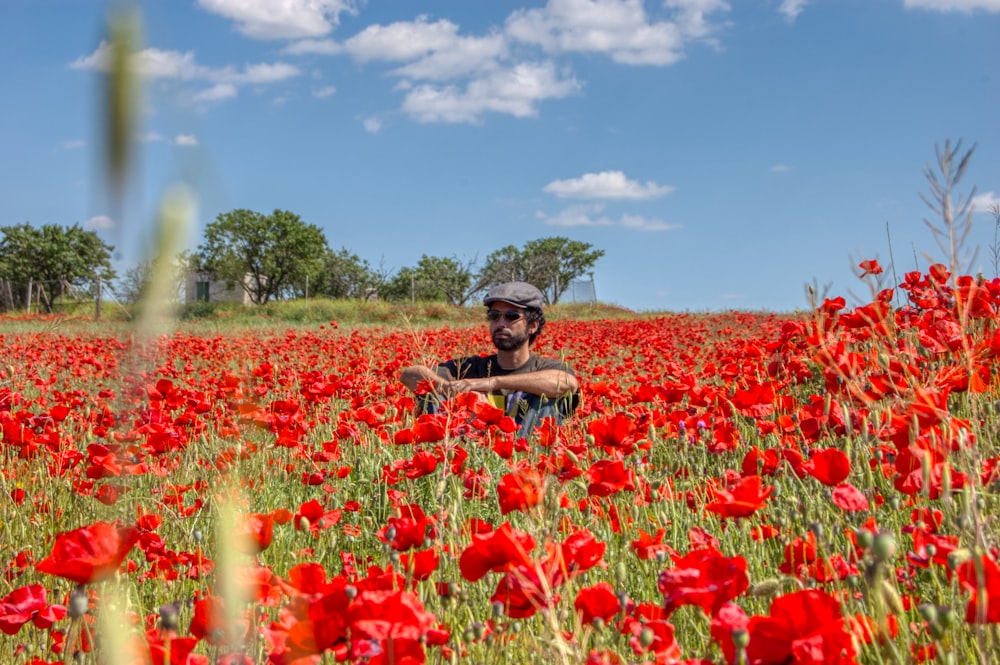 woman in brown hat surrounded by red flowers