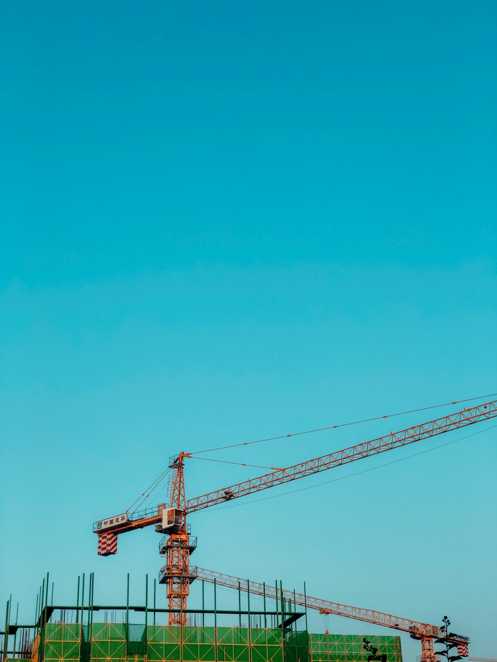 orange crane under blue sky during daytime