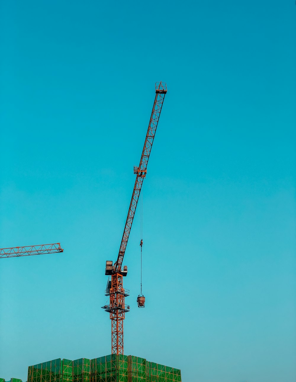 orange crane under blue sky during daytime