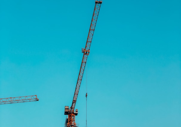 orange crane under blue sky during daytime