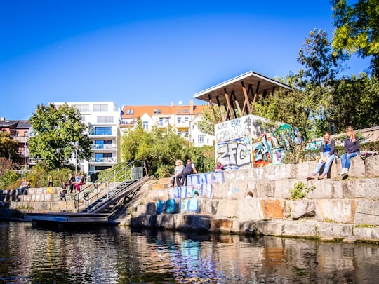 white and brown concrete building near body of water during daytime in Leipzig Germany