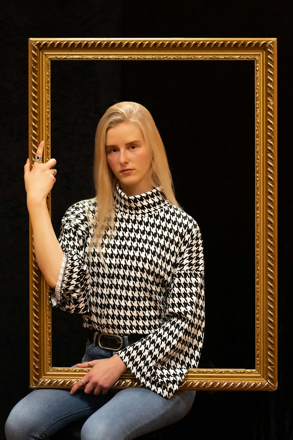 woman in black and white checkered dress shirt holding brown wooden stick