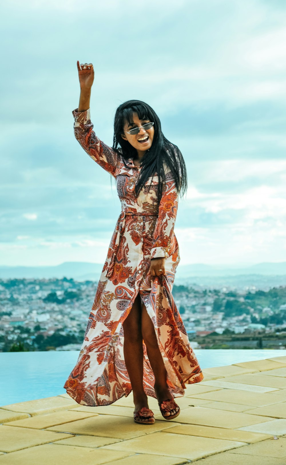 woman in red and white floral long sleeve dress standing on beach during daytime