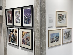 A gallery wall showcasing a variety of framed canvas artworks in different styles and sizes.