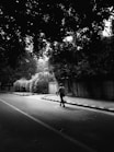 grayscale photo of man walking on road