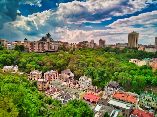 A vibrant cityscape of Paramaribo with modern homes and lush greenery under a bright sky.