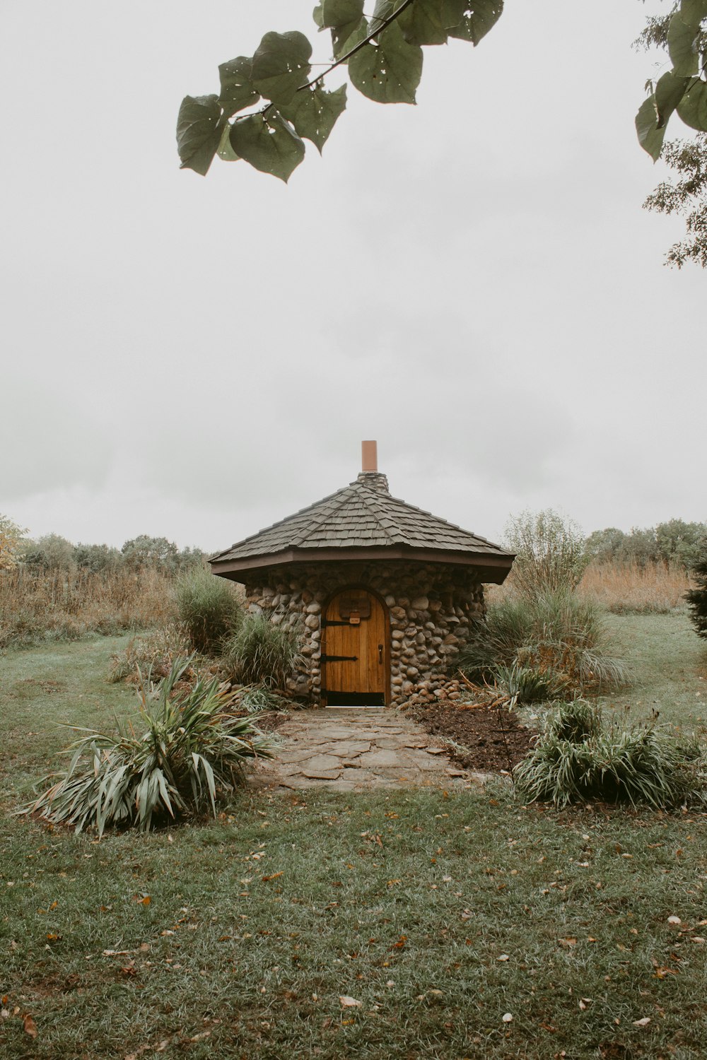 brown wooden house near green grass field during daytime