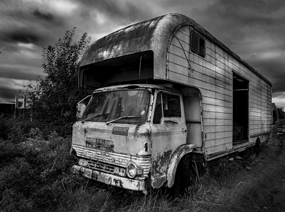 an old truck is parked in a field