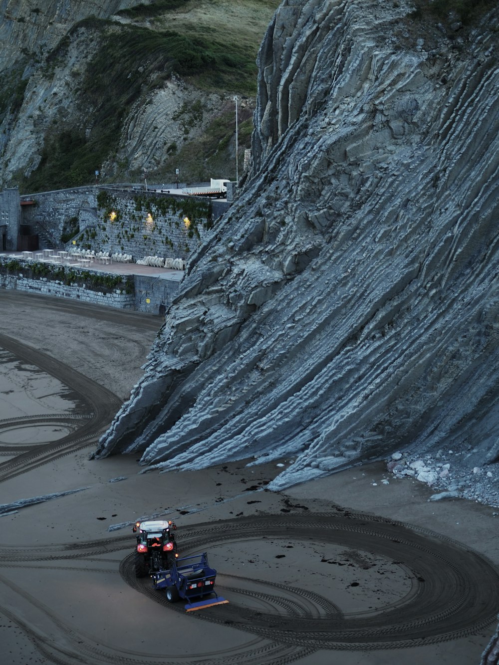 a car driving on a track near a mountain