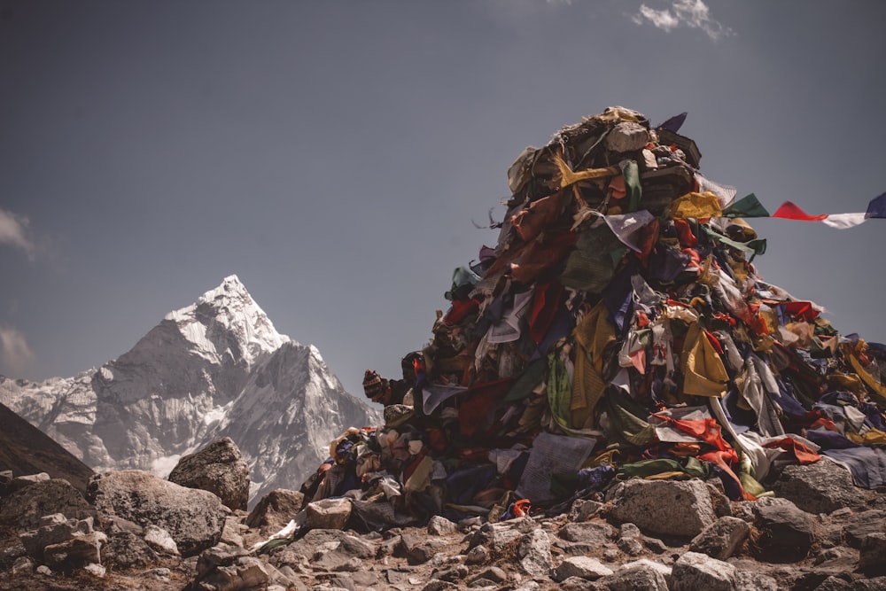 assorted color hiking bags on rocky ground near snow covered mountain during daytime