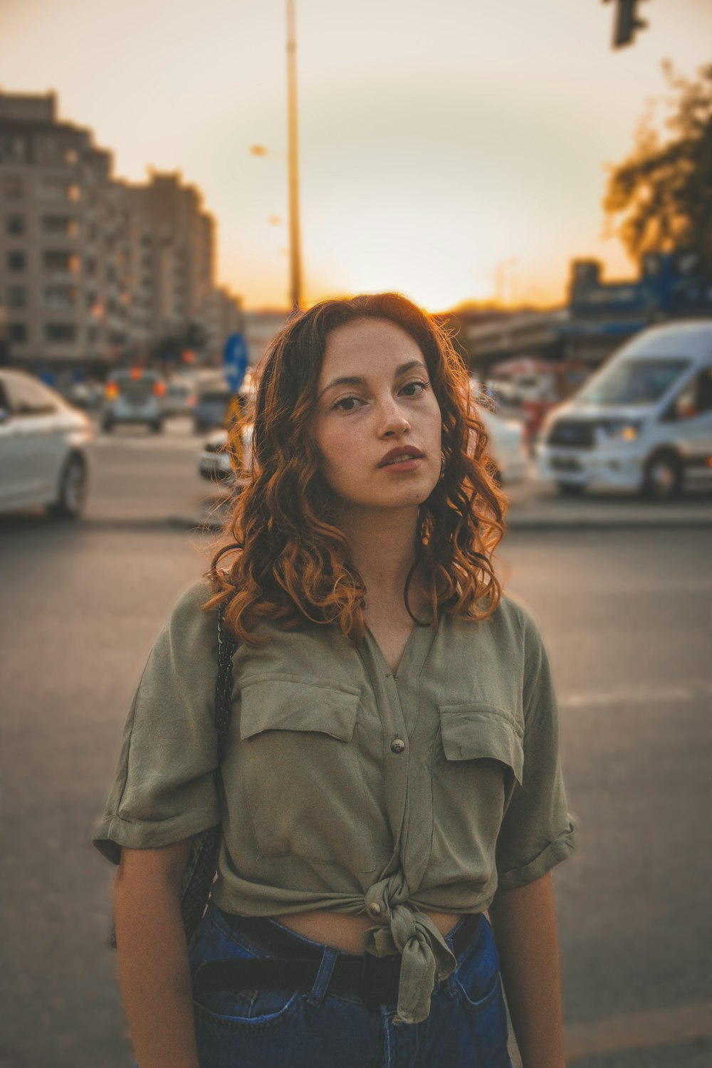 woman in gray button up shirt standing on road during daytime