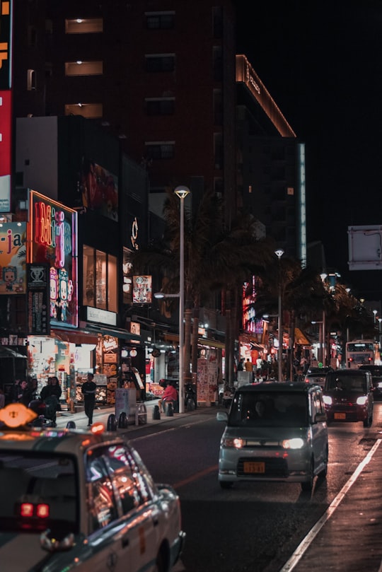 cars parked on side of the road during night time in Naha Japan