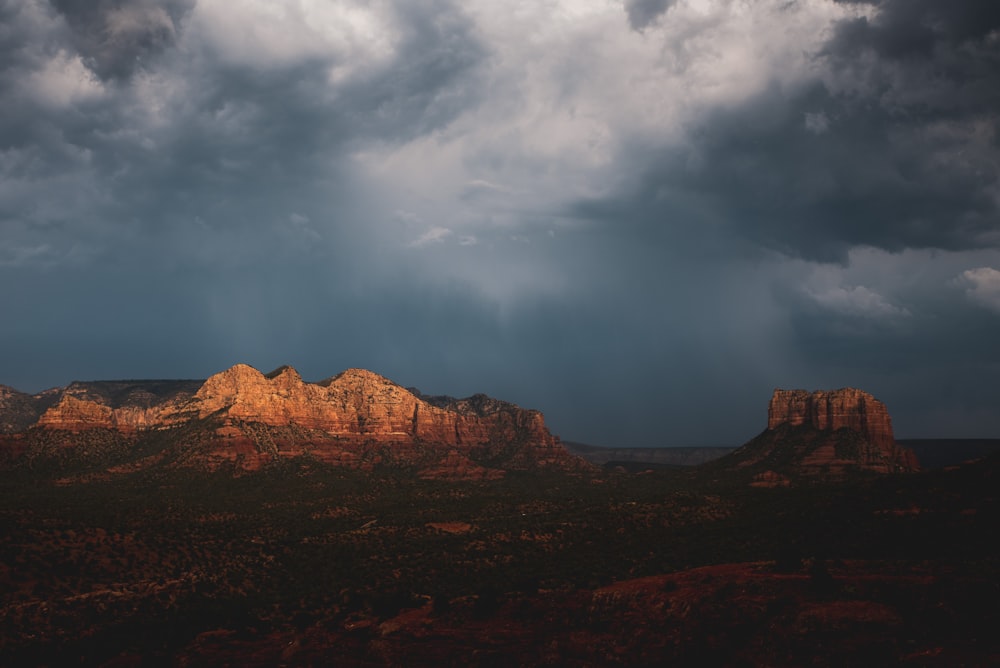 brown rocky mountain under white clouds