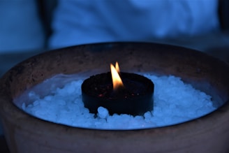 Close-up of a minimalist concrete pot with a delicate candle flame.