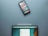 A smartphone with various app icons is placed above a tablet with a stylus resting on its edge. The tablet screen displays an application interface with options.