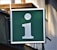 A large green signboard with a white lowercase 'i' symbol, often representing information. It is mounted on the side of a building, with a small plant visible in the upper corner.