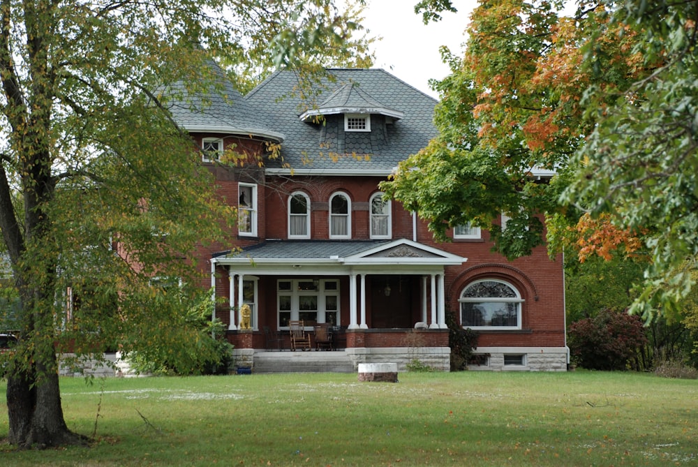 brown and white wooden house near green trees during daytime