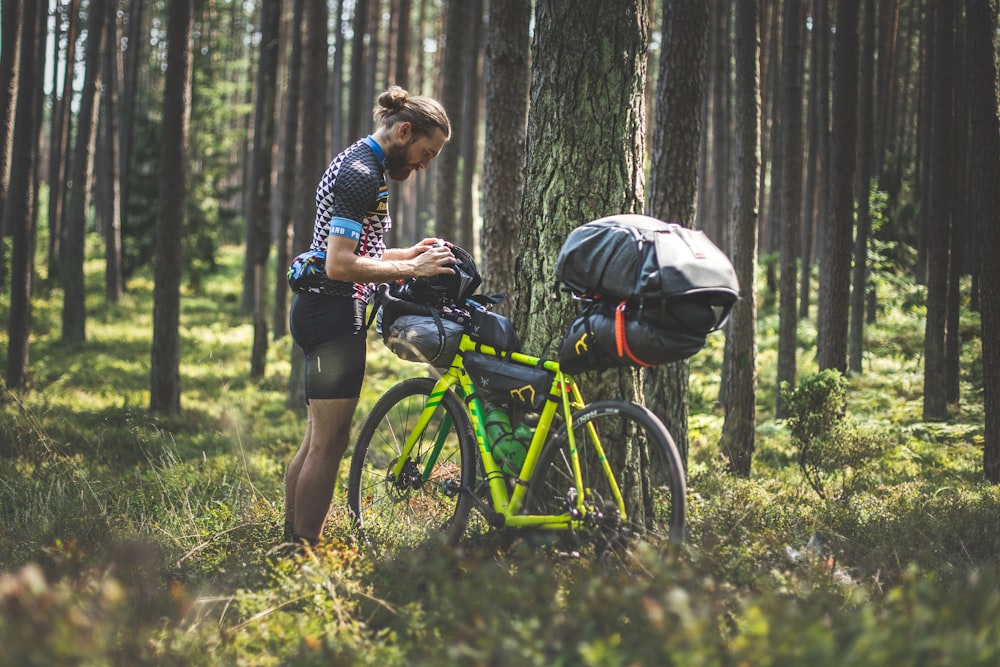 man in blue and white plaid shirt and black shorts riding yellow bicycle