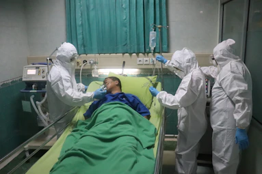 man in white scrub suit lying on hospital bed