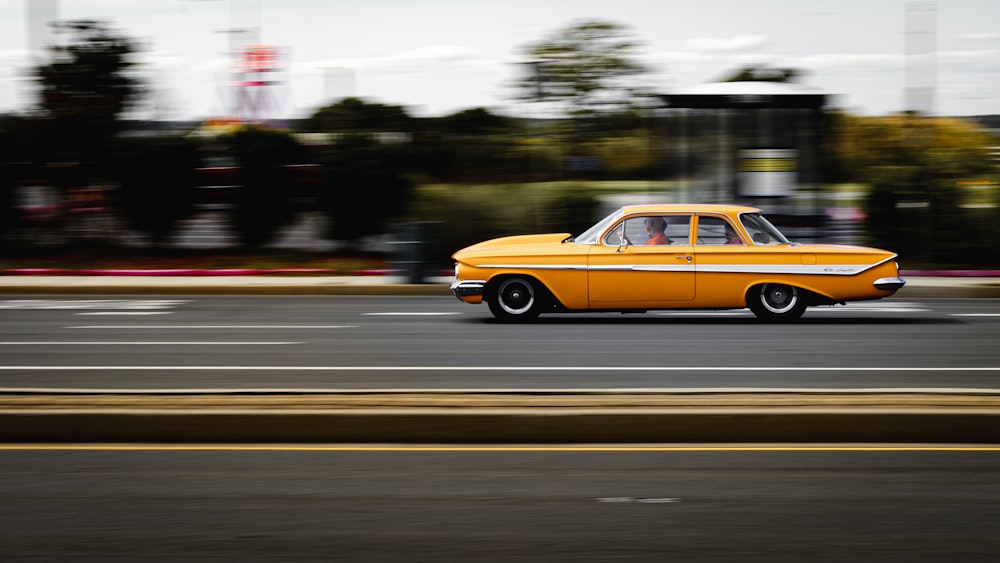 yellow sedan on road during daytime