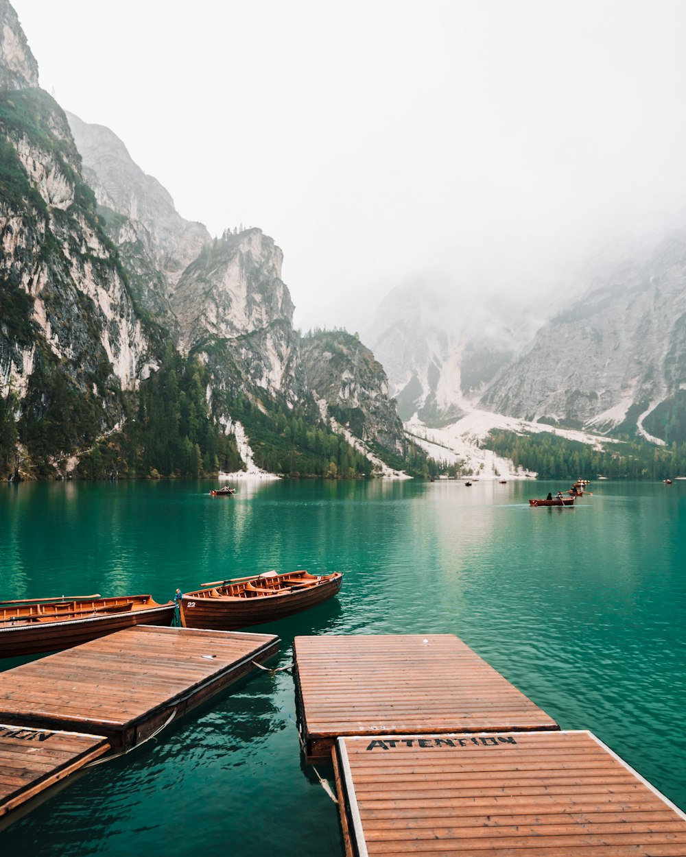 brown wooden dock on lake near mountain during daytime