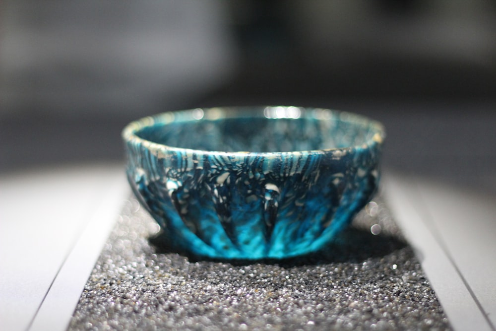 blue glass bowl on gray marble table