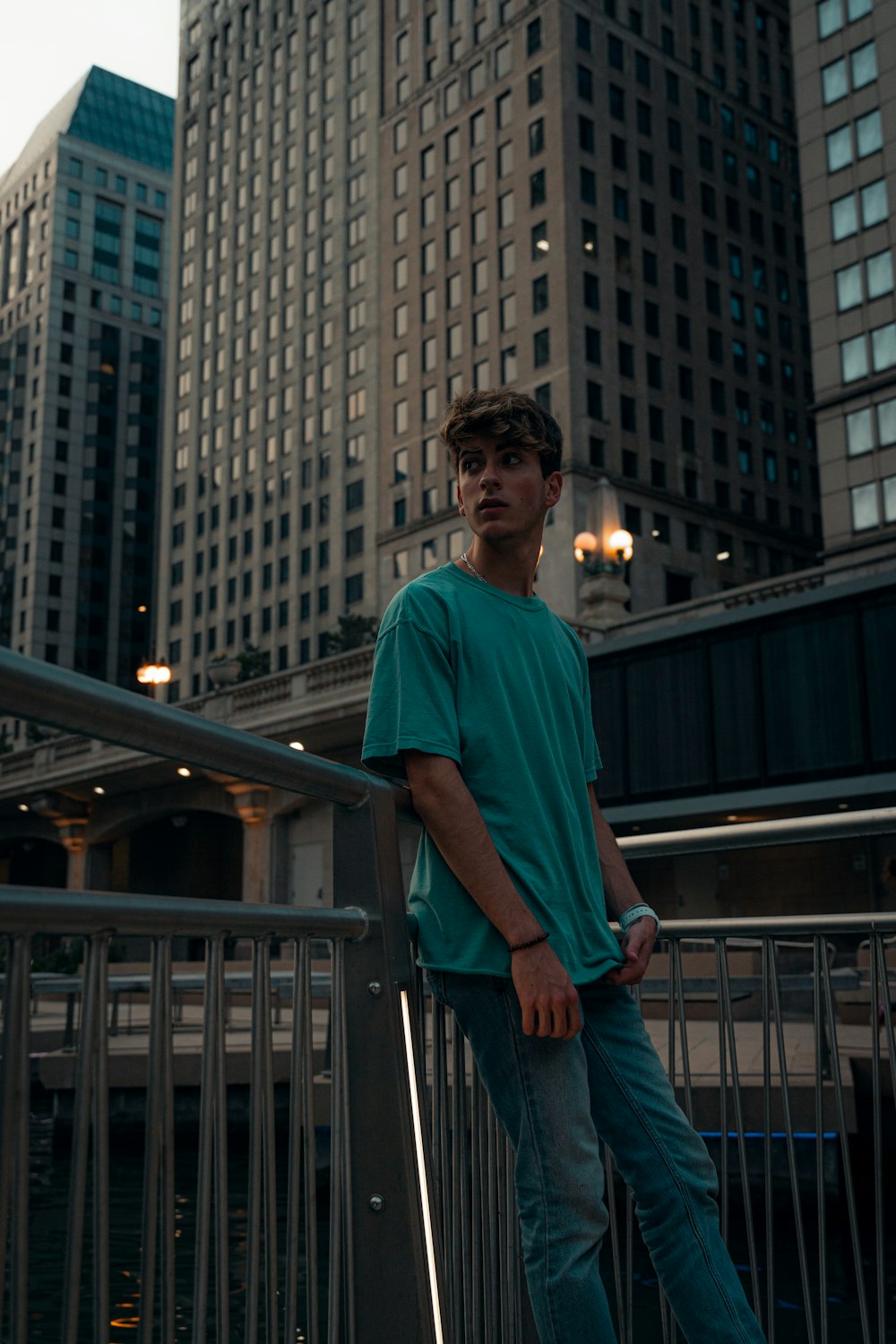 man in blue crew neck t-shirt standing near black metal railings