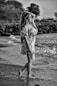 grayscale photo of girl in dress standing on road