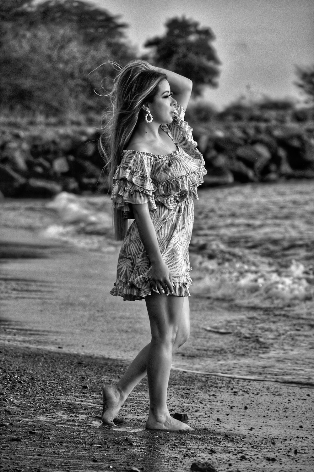 grayscale photo of girl in dress standing on road