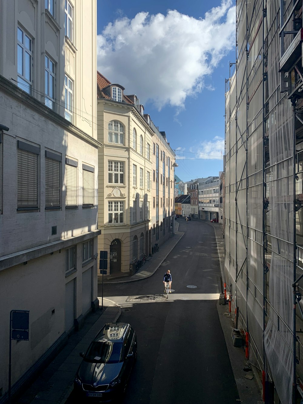 cars parked on the side of the road in between buildings