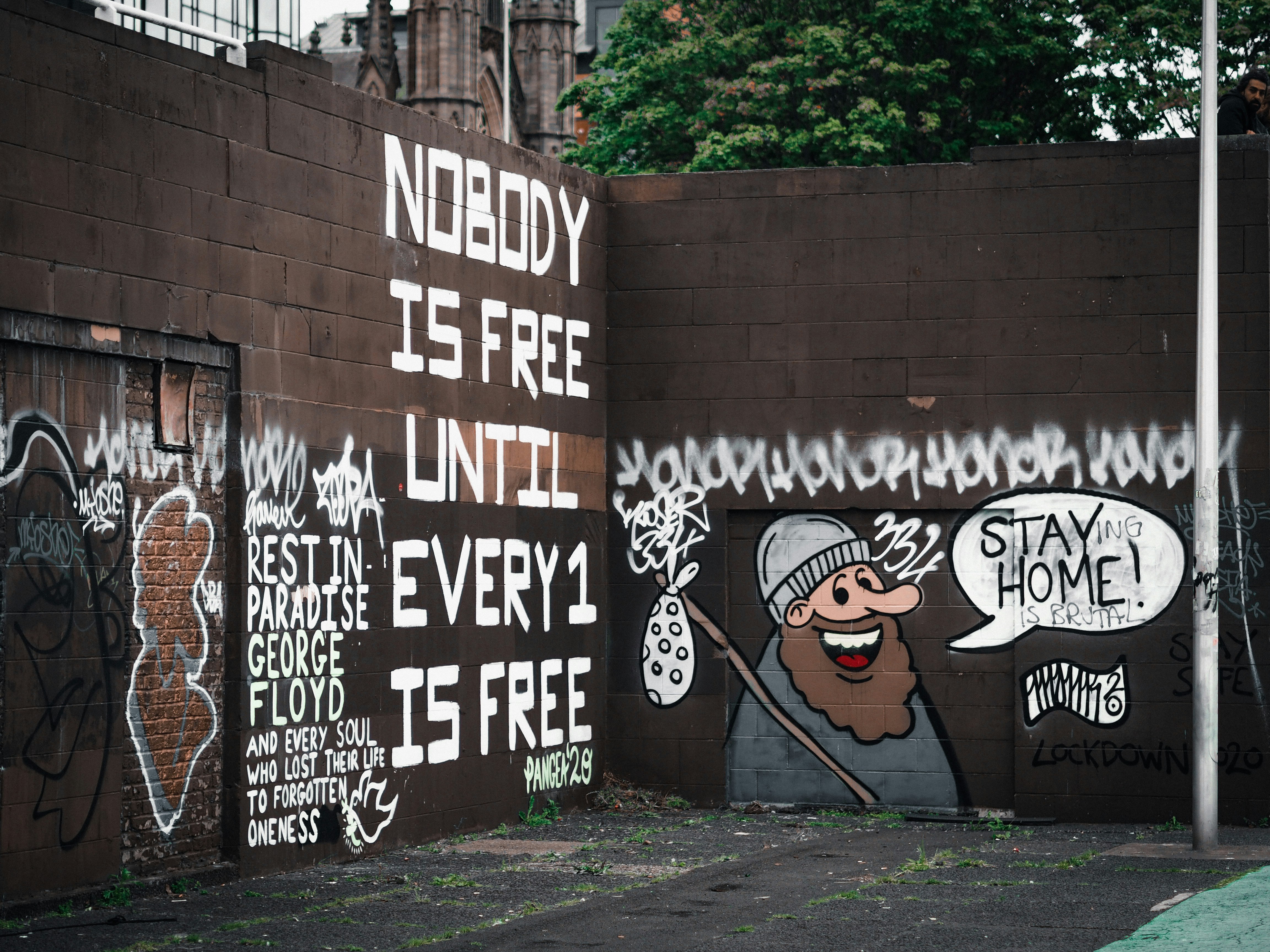 black and white graffiti on brown brick wall