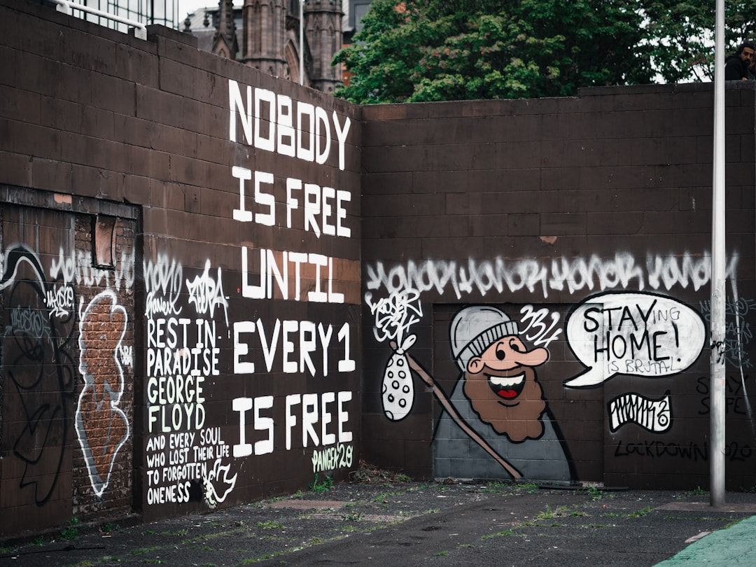 black and white graffiti on brown brick wall