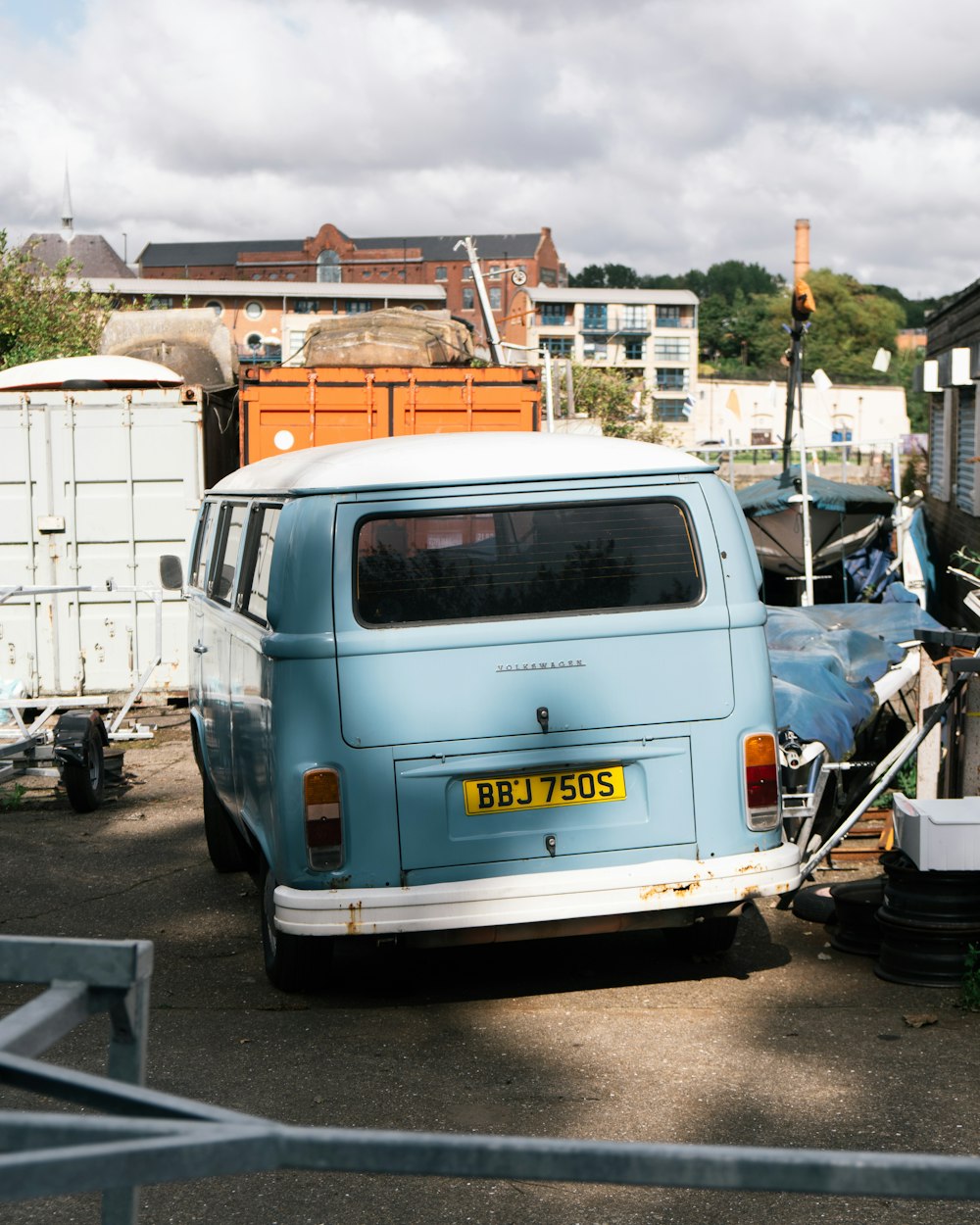 white and blue volkswagen van parked beside white van during daytime