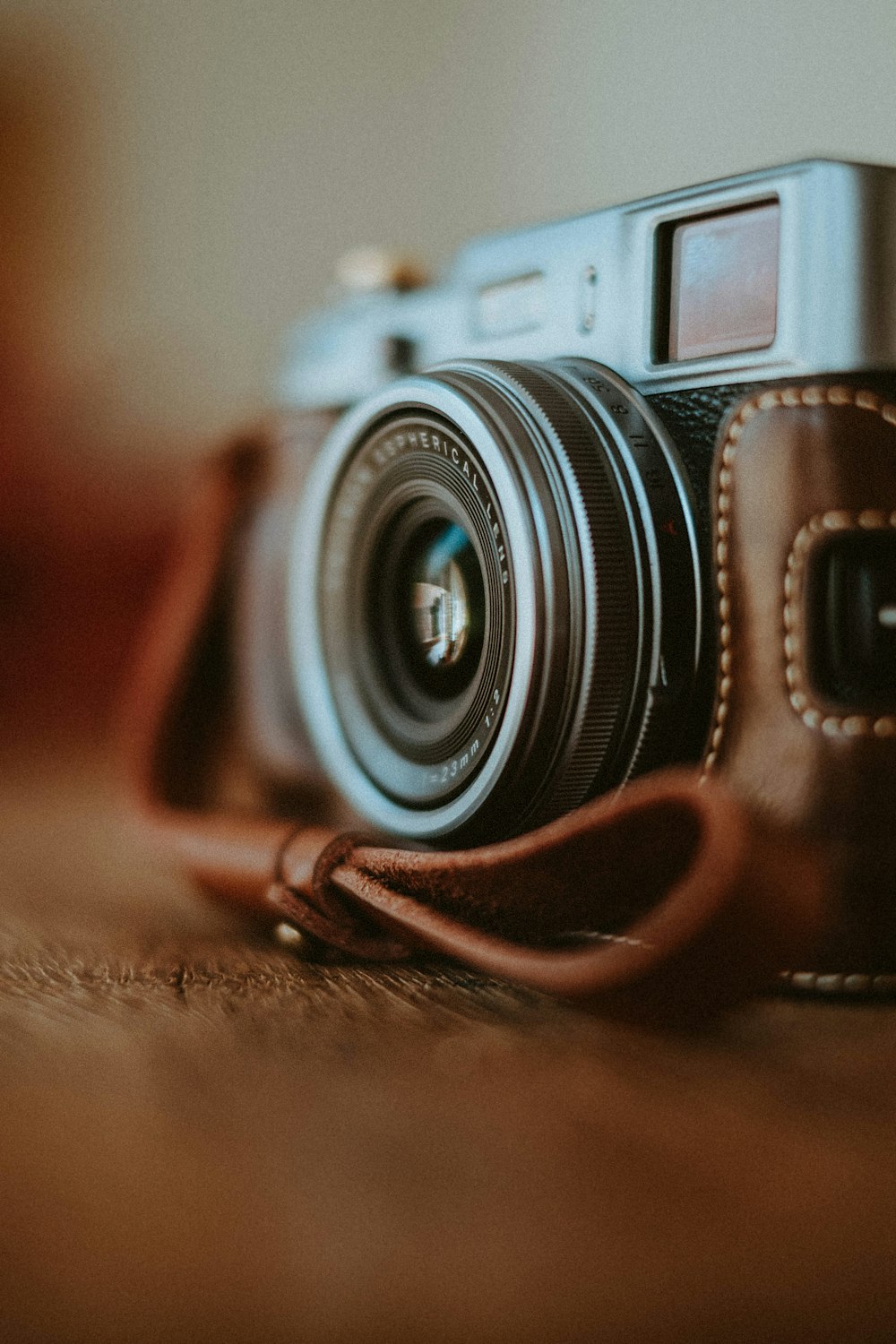 black and silver camera lens on brown leather strap