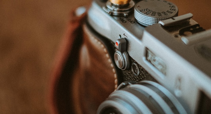 black and silver camera on brown wooden table