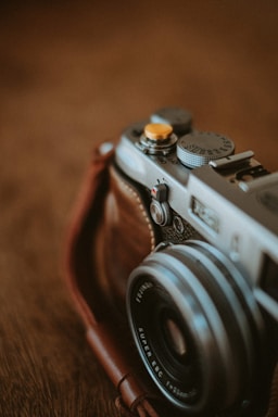 black and silver camera on brown wooden table