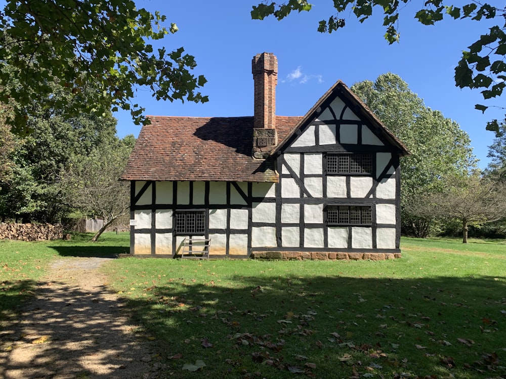 white and brown wooden house near green trees under blue sky during daytime