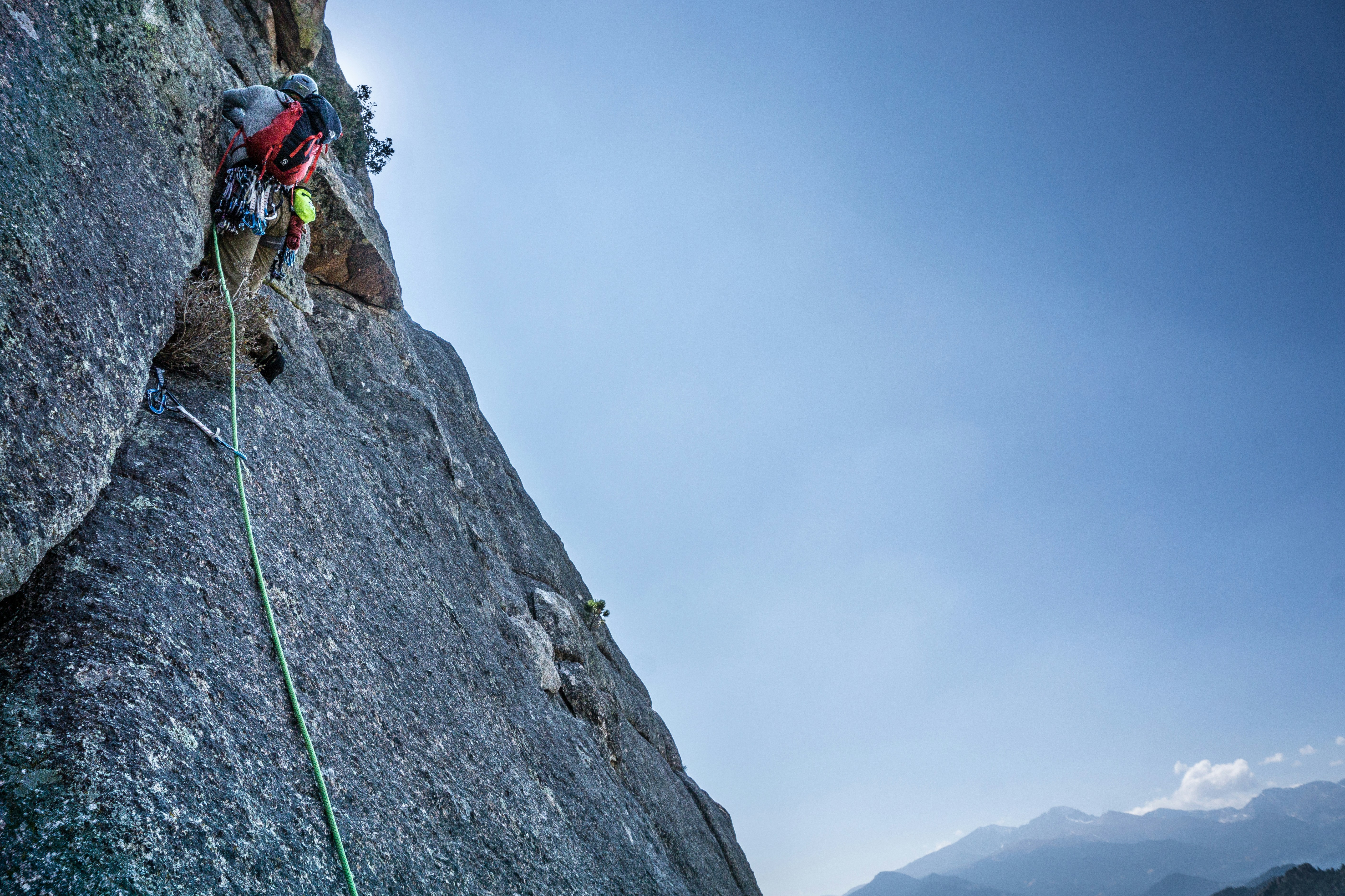 man climbing on rocky mountain during daytime photo Free Blue Image on Unsplash