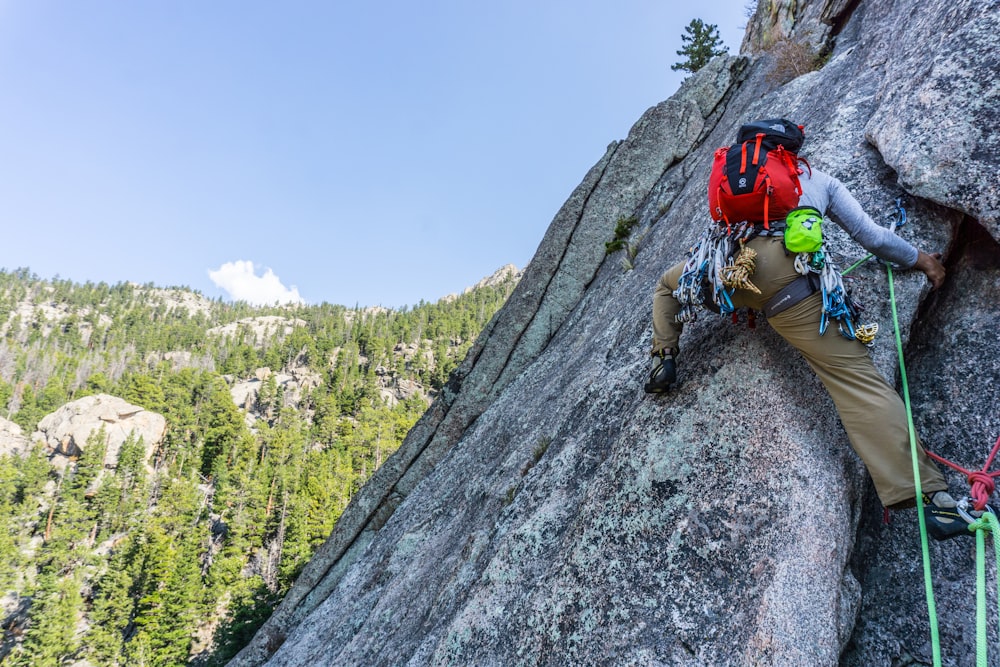 man in red helmet climbing mountain during daytime
