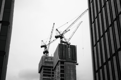 Cranes operating over a dense city block with ongoing mixed-use development.
