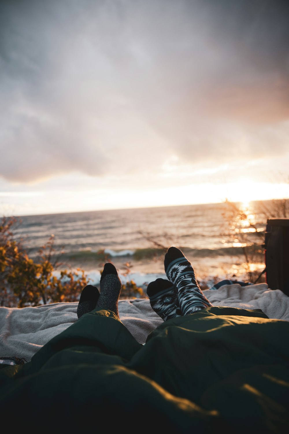 person in black pants and black shoes sitting on rock during daytime