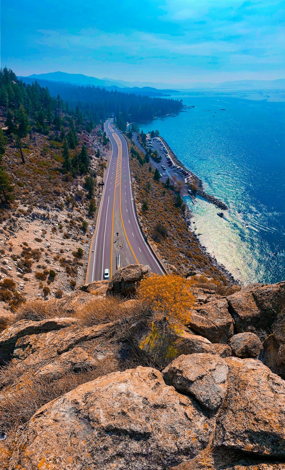 aerial view of road near body of water during daytime