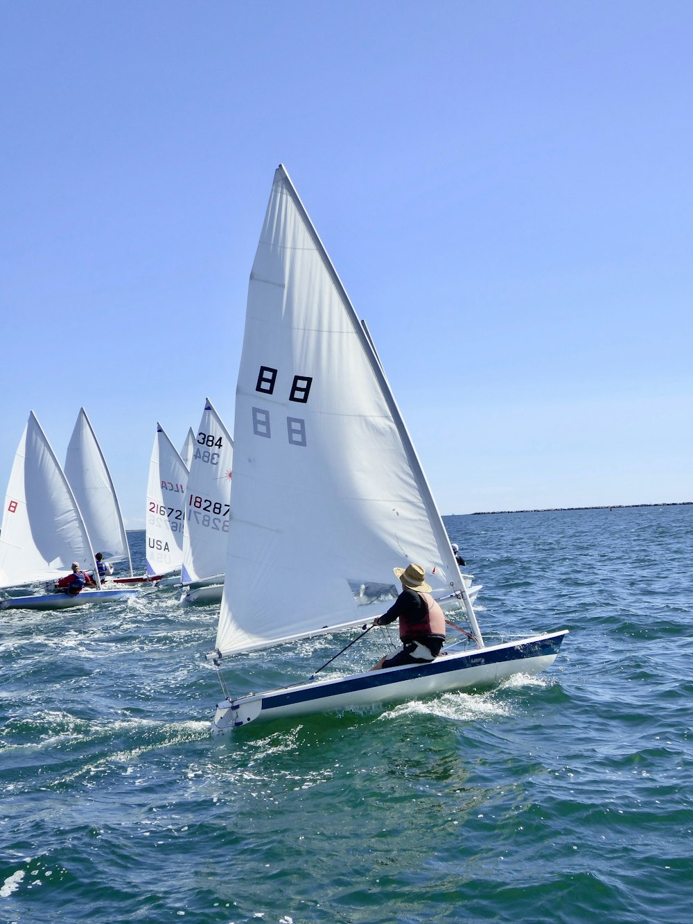 2 white sail boats on sea during daytime