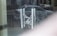 A chain and padlock secure metal handles on a glass door, with a reflection of a parked car and street scene visible in the background. The atmosphere appears quiet and subdued.