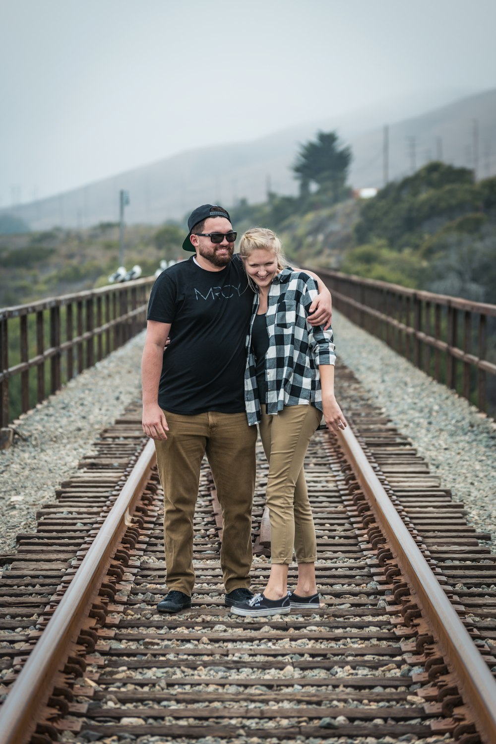 man in black crew neck t-shirt standing beside woman in black and white plaid shirt